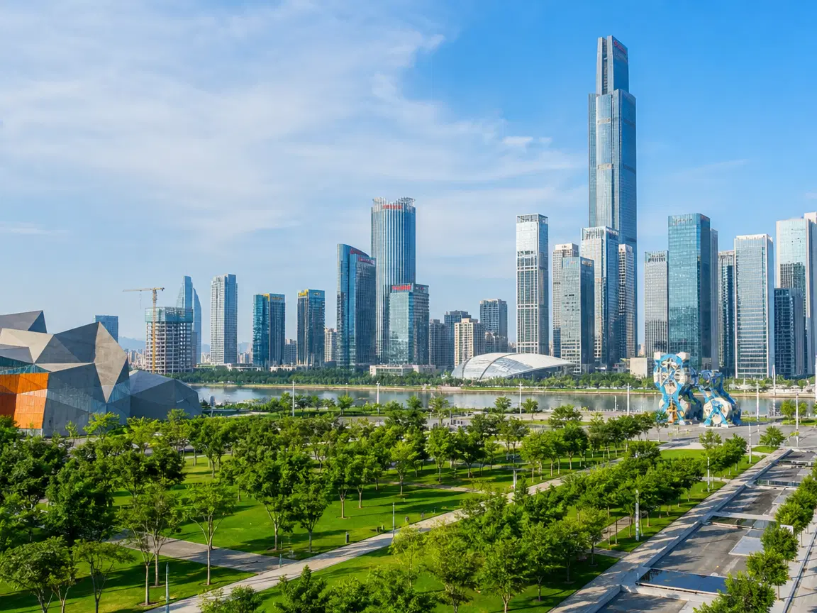 Panoramic view of a modern urban district with high-rises and green parks under a clear blue sky.